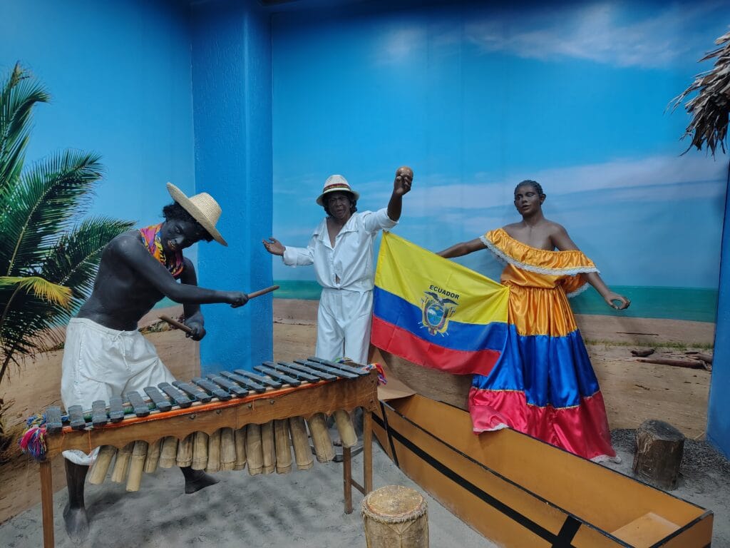 Afro-Ecuadorian musicians performing with traditional marimba instruments in a museum exhibit.