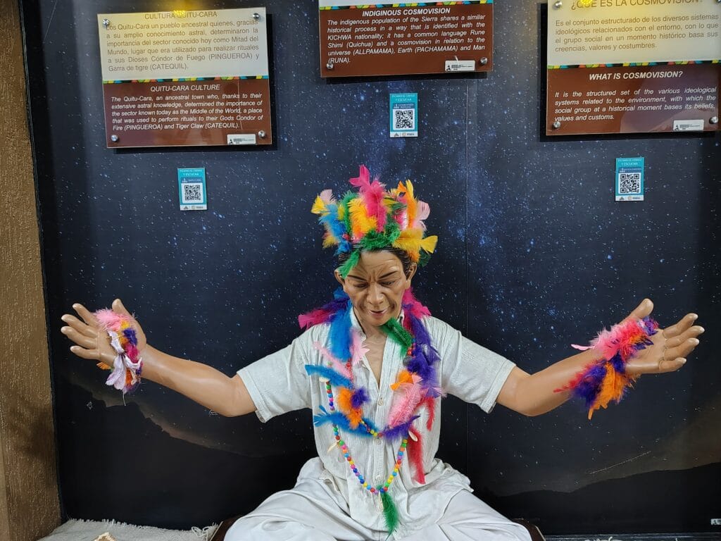Amazonian ceremonial figure wearing colorful feathers inside the Ethnographic Museum at Mitad del Mundo.