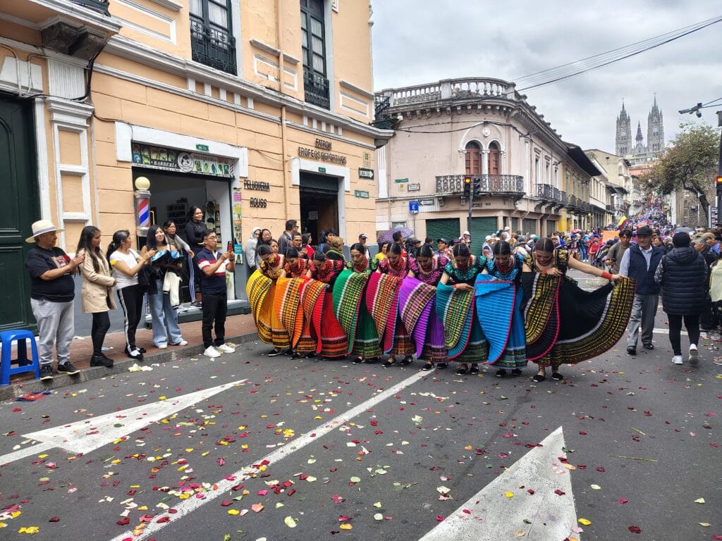 Performers wearing colorful traditional Ecuadorian clothing during the Fiestas de Quito parade.