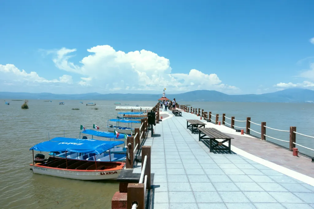A small boat by a dock on Lake Chapala in Ajijic, Jalisco, Mexico, with hills across the water
