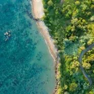 Aerial view of Da Nang's long sandy coastline with turquoise water and green hills in central Vietnam
