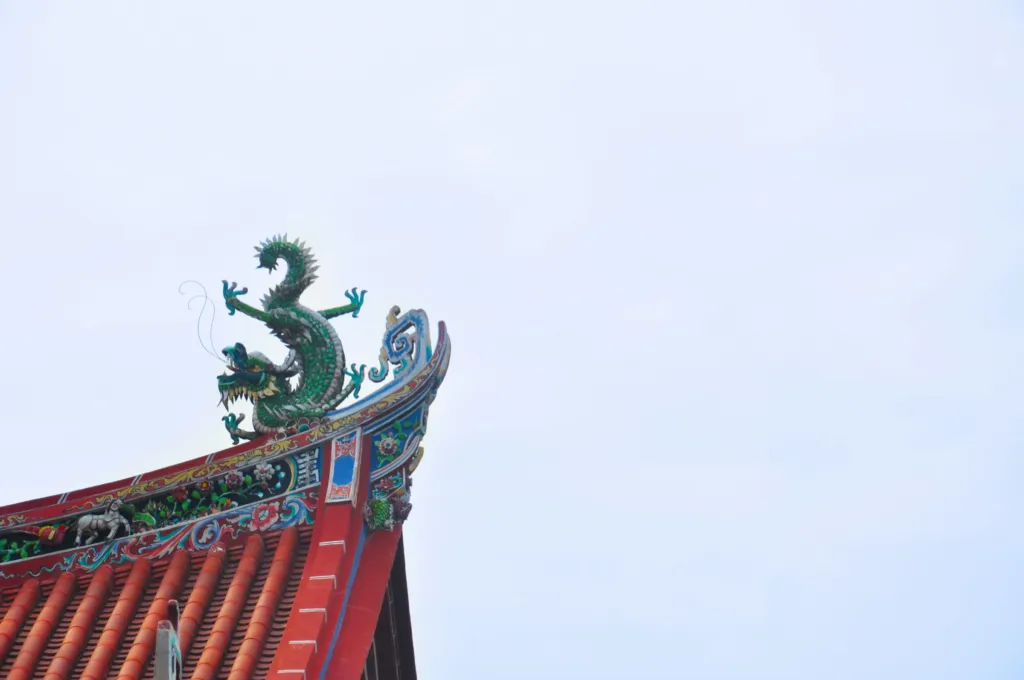 An ornate red Chinese temple roof with dragon carvings in George Town, Penang, Malaysia