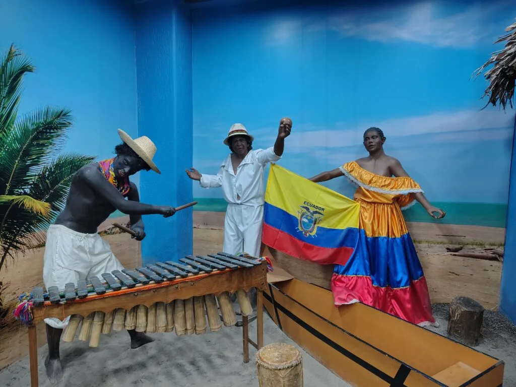 Afro-Ecuadorian musicians performing with traditional marimba instruments in a museum exhibit.