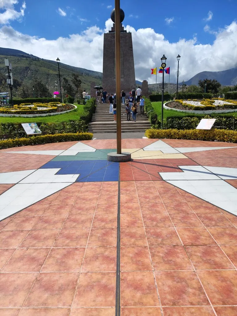 Visitors walking through the central plaza of Ciudad Mitad del Mundo in Ecuador.